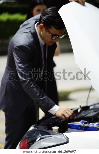 the\
business man try to fixed the broken car on the way\
