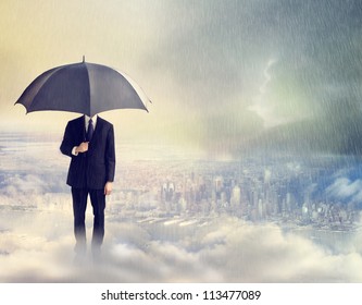 Business Man With Umbrella Above The City