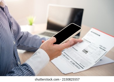 Business Man Uses His Phone To Scan A Barcode To Pay His Monthly Credit Card Bill After Receiving An Invoice. Online Bill Payment Concept