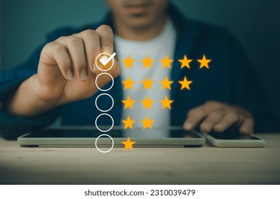 Business man uses a pen to write a checkmark in the box, the highest satisfaction rating is five stars. rating evaluation and customer satisfaction reviews with copy space, Customer satisfaction conce