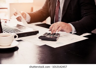 A business man using calculator for calculate expenses bills in his workplace. Business concept. - Shutterstock ID 1013142457