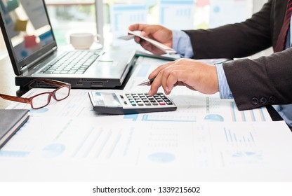 A business man using calculator for calculate expenses bills in his workplace. Business concept.