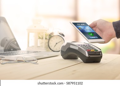 A business man using his mobile to made a payment wireless with EDC machine or credit card terminal. Mobile payment concept with fake credit card.