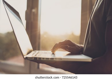 Business man using laptop computer. Male hand typing on laptop keyboard