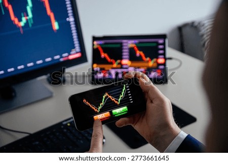 Business man using a mobile device to trade stocks or currency on a financial market. 