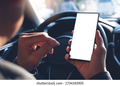 Business Man Using Mobile Smart Phone, Checking Address Location Via Navigator Application, Driving A Car. Driver Hand Holding And Looking At Cellphone Inside A Car, White Screen Mockup