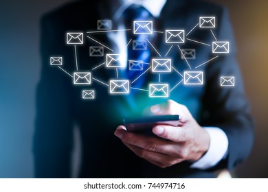 Business man using modern mobile phone with email icons around it. - Shutterstock ID 744974716