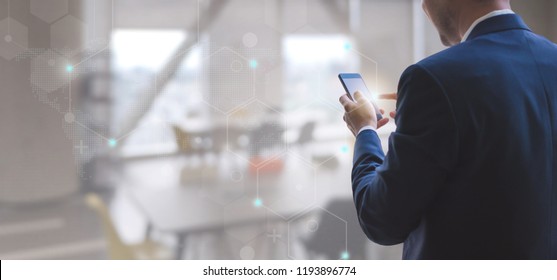 Business Man Using Smart Phone On Interior Office Space With Futuristic Technology Connection Shape Over The Network Connection Background.