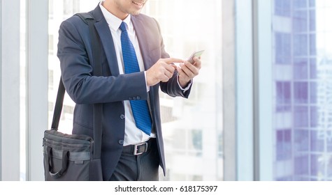 Business Man Using Smart Phone On Window With City Building Background And Copy Space.