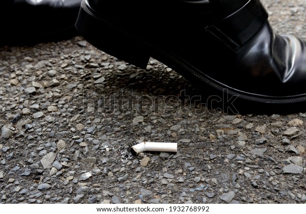 Business man walking near littered cigarette in
asphalt street