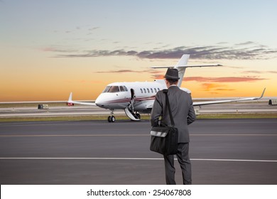 Business Man Walking Toward A Private Jet