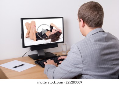 business man watching erotic video on his personal computer in office