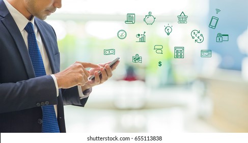 Business Man Wear Suit Using Mobile Phone To Pay On Mobile Banking Features Icon With Blur Office Background With Bokeh Light,fintech Technology Concept.