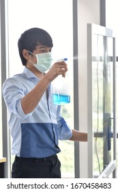 Business Man Wearing Medical Mask And Using Window Cleaner To Kill Virus