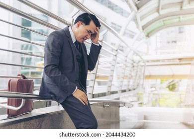 Business Man Wearing A Suit Is Stressed From Work Stopped On A Public Walkway , He Had A Serious ,worried Face Because He Was Fired From His Job The Company He Works For Is About To Go Bankrupt