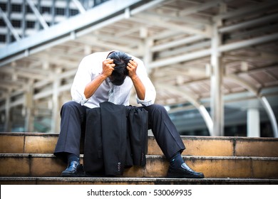 Business man who lost job abandoned lost in depression sitting on the subway stair suffering emotional pain. Businessman who have trouble with his job.Portrait of unhappy man under depression.