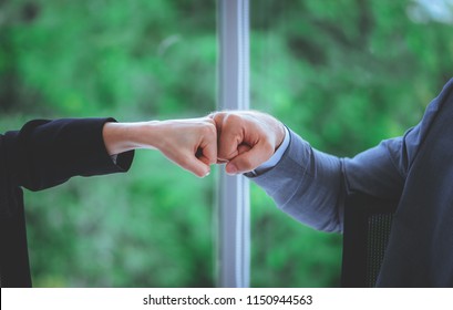 Business man and woman business couple fist bump hand together for team work