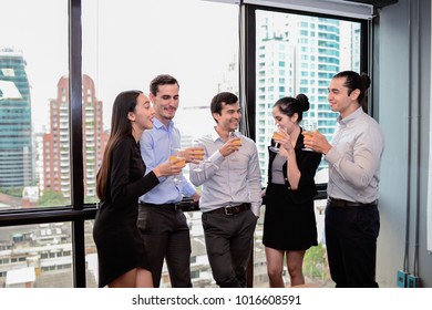 business man are business woman drinking champagne talking and smiling while celebrating in office, successful business concept. - Shutterstock ID 1016608591