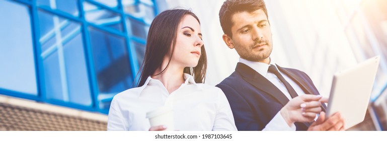 The Business Man And Woman Stand With A Tablet