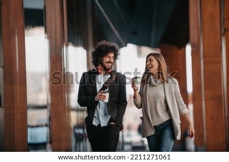 Business man and business woman talking and holding luggage traveling on a business trip, carrying fresh coffee in their hands.Business concept