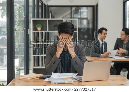 business man at work on his laptop while suffering from a headache and anxiety with a working while struggling with fatigue stress