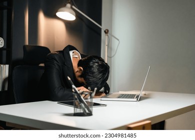 The business man worked so hard that he fell asleep at his desk. Working overtime because it's almost time for the deadline. He was tired from job and took a nap. - Shutterstock ID 2304981485