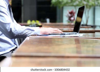 Business Man Working And Analyzing Financial Figures On A Graphs On A Laptop Outside