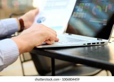 Business Man Working And Analyzing Financial Figures On A Graphs On A Laptop Outside