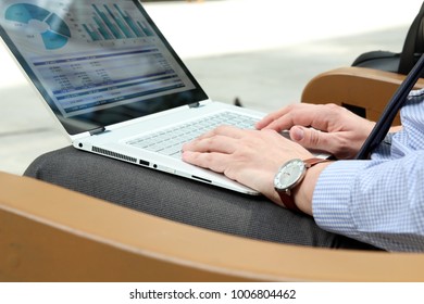 Business Man Working And Analyzing Financial Figures On A Graphs On A Laptop Outside