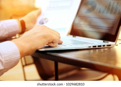 Business Man Working And Analyzing Financial Figures On A Graphs On A Laptop Outside