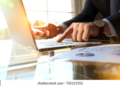 Business man working and analyzing financial figures on a graphs on a laptop  - Shutterstock ID 735127255