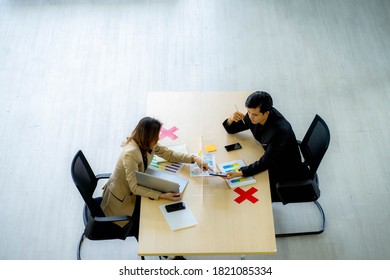 Business Man Working Apart From Colleague  In The Office. New Normal Social Distancing Concept.