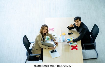 Business Man Working Apart From Colleague  In The Office. New Normal Social Distancing Concept.