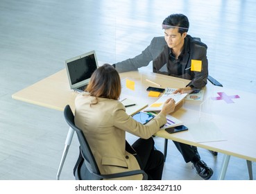 Business Man Working Apart From Colleague  In The Office. New Normal Social Distancing Concept.