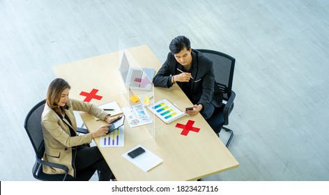 Business Man Working Apart From Colleague  In The Office. New Normal Social Distancing Concept.