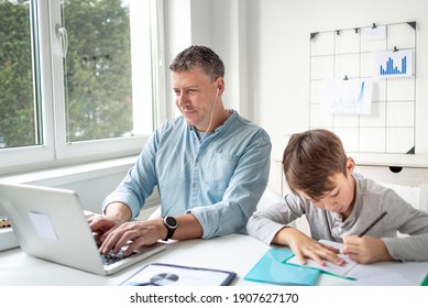 Business man working from home doing homeoffice and his son has homeschooling during corona crisis