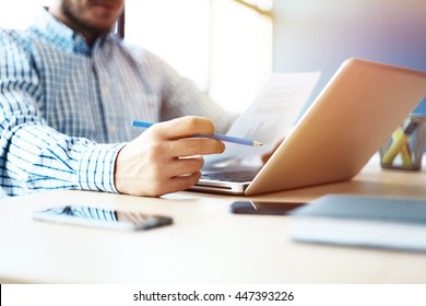 Business Man Working At Office With Laptop And Documents On His Desk. Analyze Plans, Papers, Hands Keyboard. Blurred Background, Film Effect