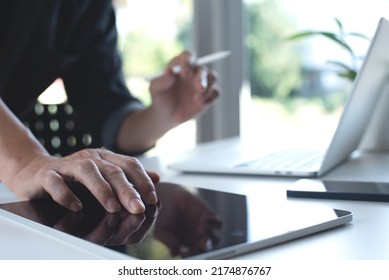 Business man working on laptop computer and digital tablet with mobile smart phone on table at home office. Male hand typing on the notebook keyboard. Young people working at home concept - Shutterstock ID 2174876767