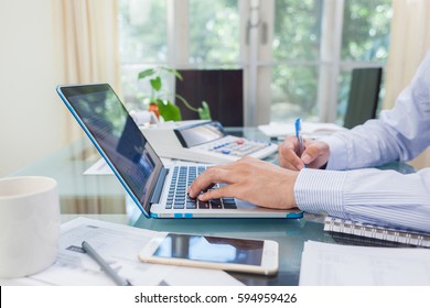 Business man working on open laptop at home office - Shutterstock ID 594959426