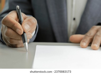business man writing with pen on a office table with grey background with people stock image stock photo