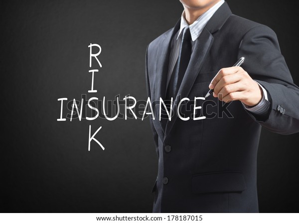 Business man writing\
Risk Insurance\
crossword