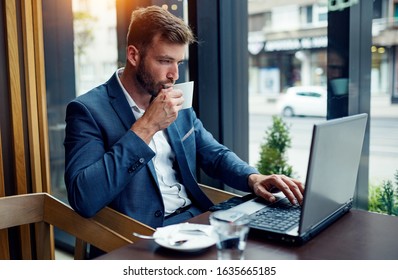 Business manager drinking coffee and using laptop - Shutterstock ID 1635665185