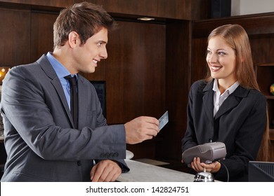 Business Manager At Hotel Reception Paying With Credit Card