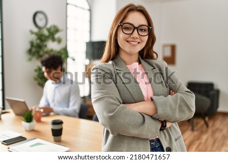 Business manager smiling happy with arms crossed gesture. Employee working at the office.