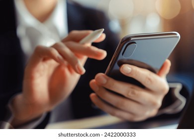 The business manager uses a smartphone and its apps for customer support, including email, chat, and phone communication. - Powered by Shutterstock