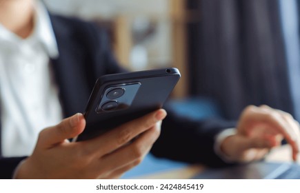 The business manager uses a smartphone and its apps for customer support, including email, chat, and phone communication. - Powered by Shutterstock