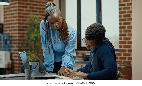 Business manager using phone call in office, explaining new company vision to increase profit. Employee and assistant reviewing documents, talking on smartphone about annual reports information. - Powered by Shutterstock