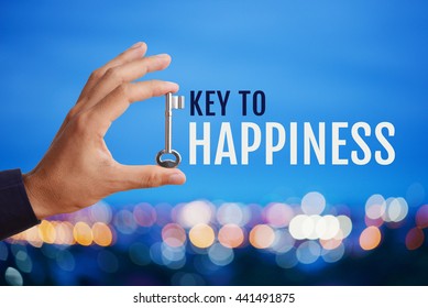 Business man's hand holding and raising key with word Key to HAPPINESS on abstract twilight bokeh night scene background, blank space for your text and design. Business concept of key to success. 