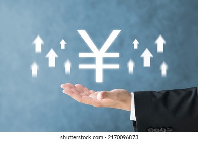 Business man's hand and Japanese yen mark with upward arrows