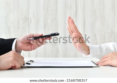 Business man's hand recommending contract and customer's hand refusing it
